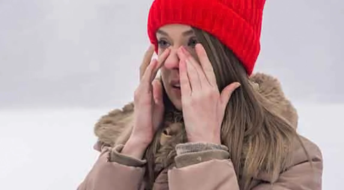 Woman having nasal congestion out in the snow