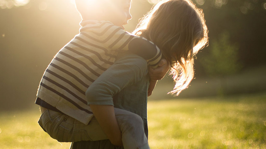 little girl carrying a boy on her back