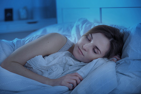 Femme dormant profondément dans un lit