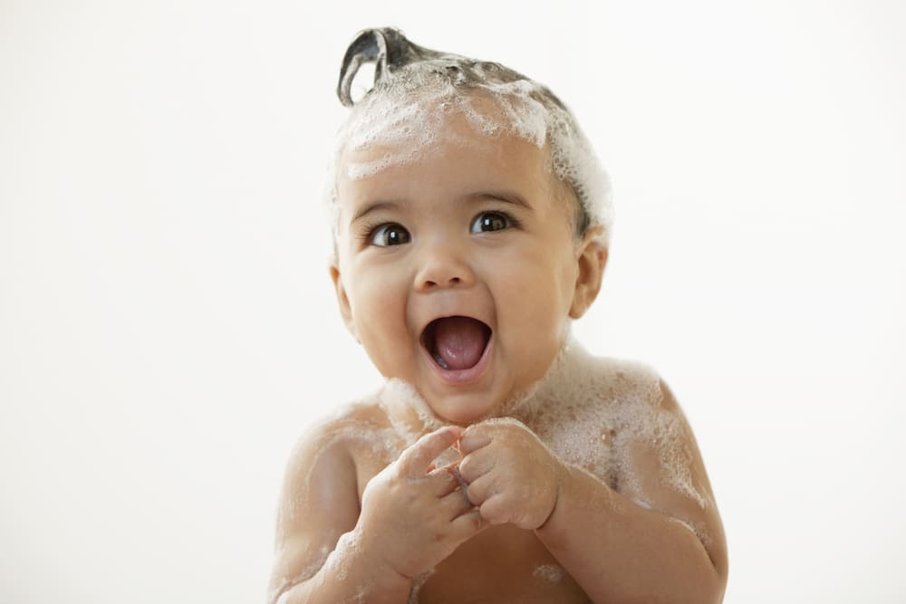 Baby with bubbles on her head and body