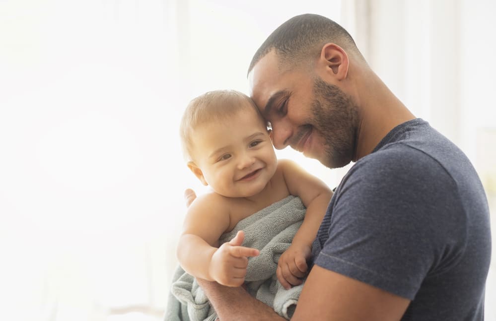 Father holding his son wrapped in towel