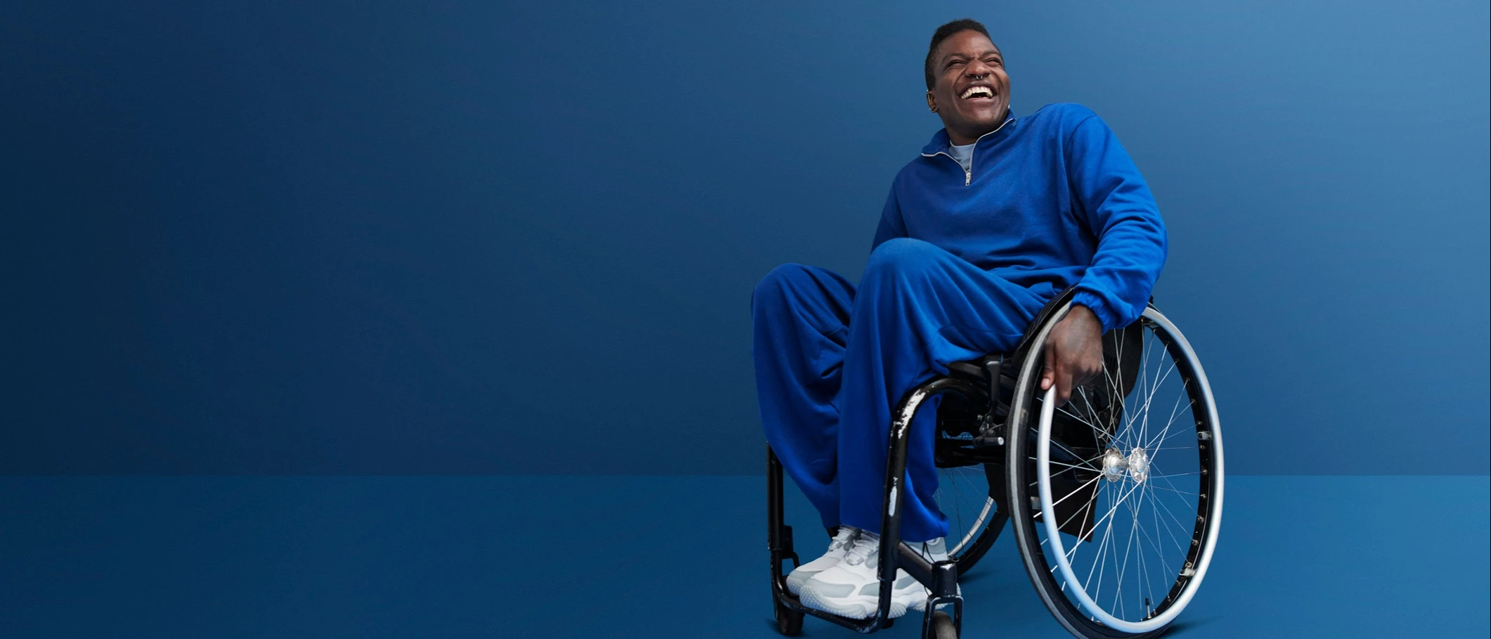 man in blue outfit sitting on a wheelchair and smiling | LISTERINE