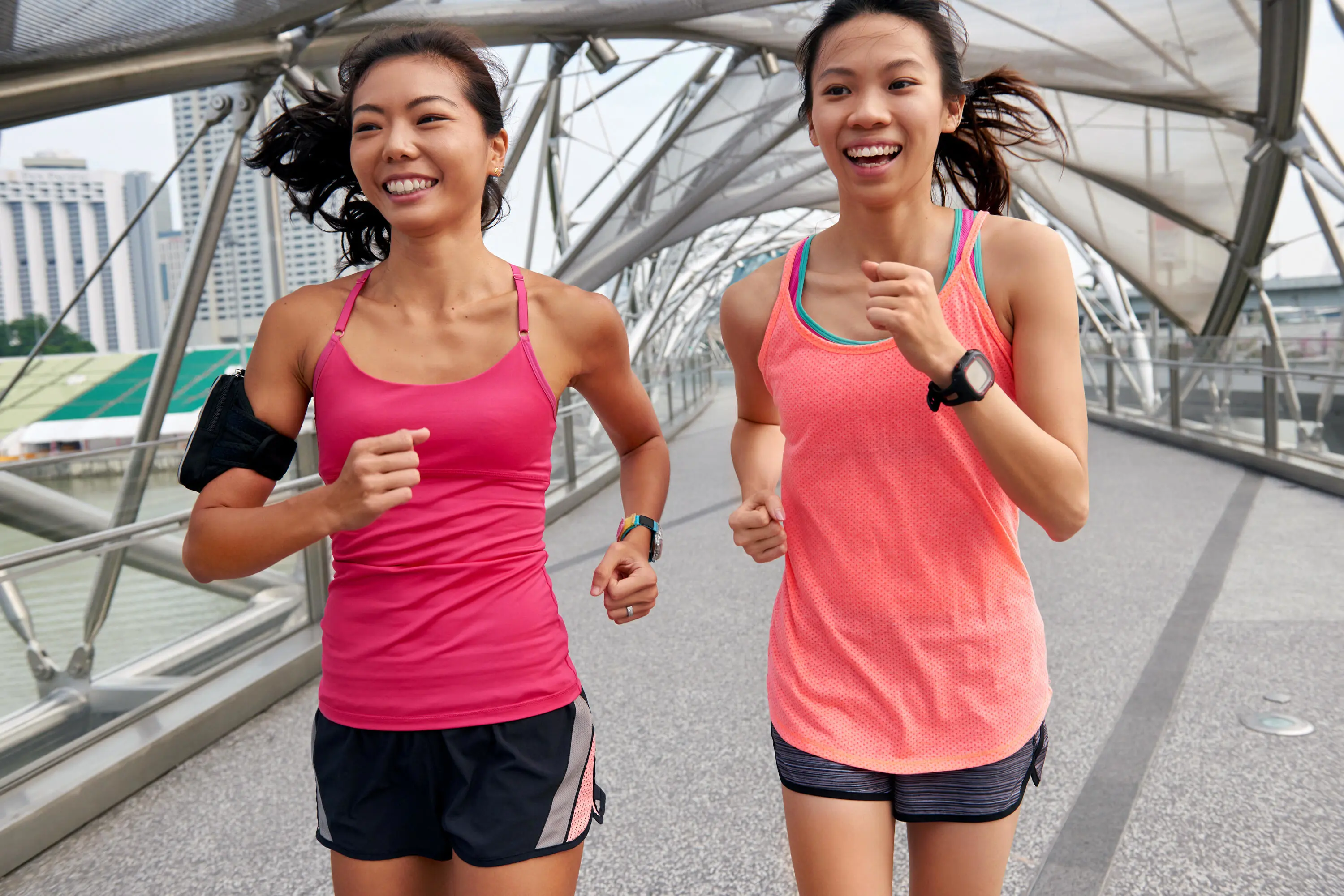  Deux jeunes femmes font du jogging ensemble sur un pont, profitant d’une séance d’entraînement active