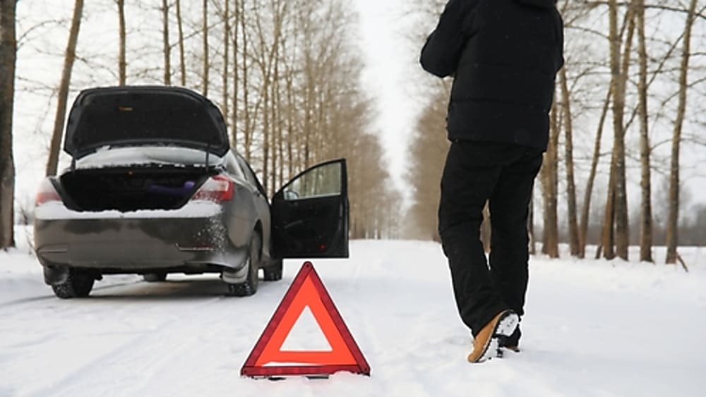 safely pulled over to work on car on snowy road