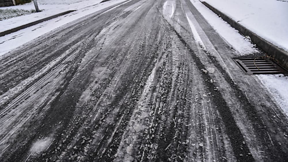 Icy and snow covered road with tire tread tracks