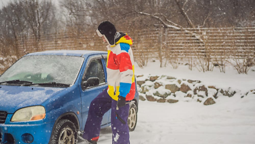 Inspecting a flat tire in the snow