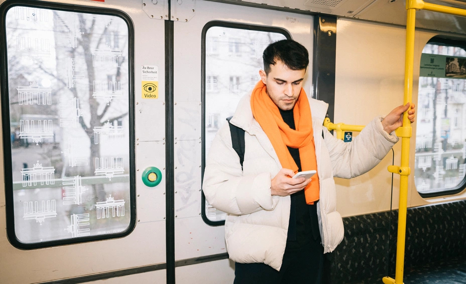 Man on public transport looking at phone