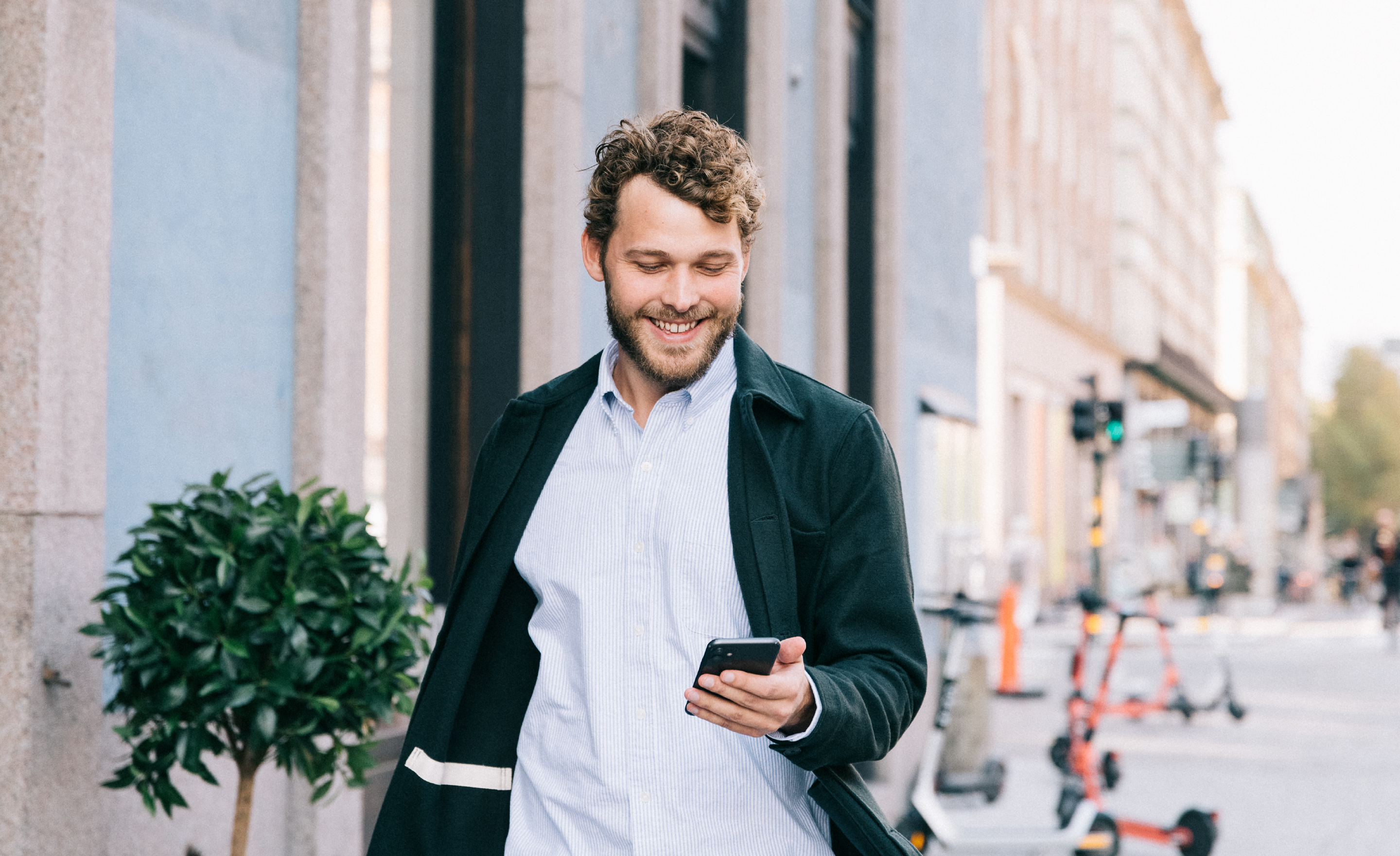 Man on a sidewalk looking at his phone