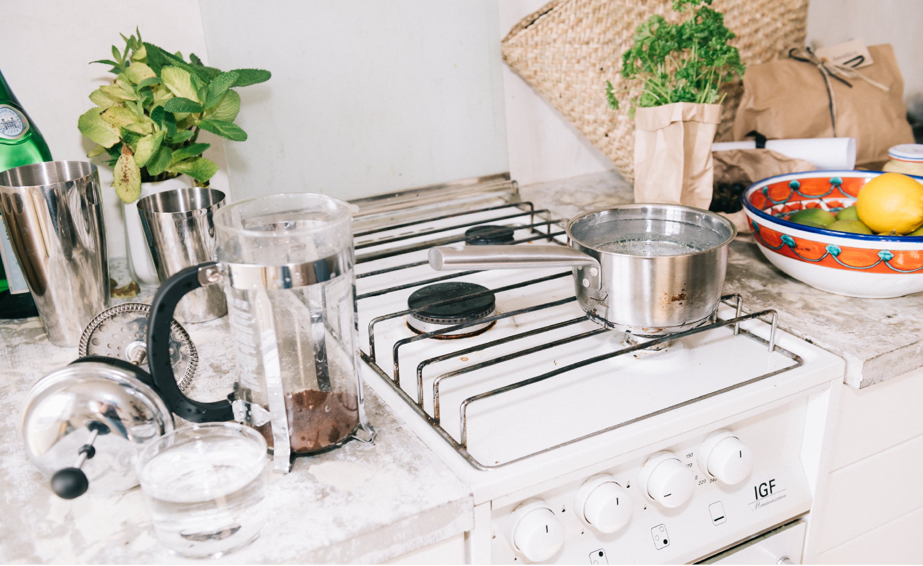 This image depicts a kitchen stove and benchtop with essential household items.