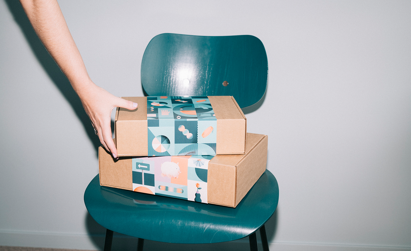 This image conveys the high volume of returns expected this Black Friday by depicting a stack of cardboard boxes and a person's hand.