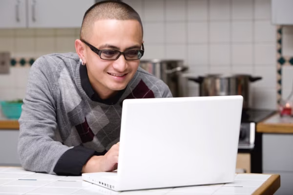 Man using laptop in kitchen