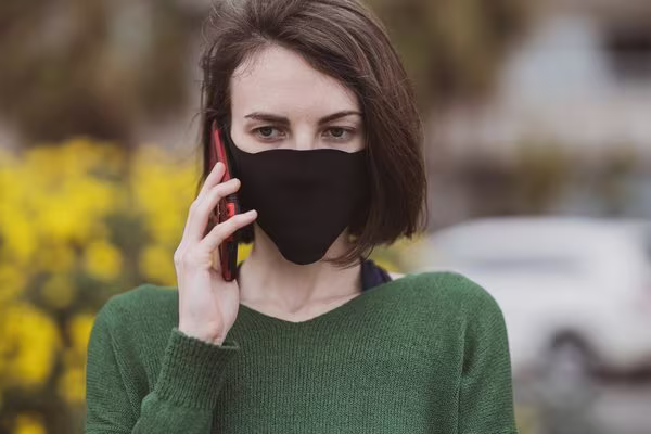 Woman wearing mask on phone
