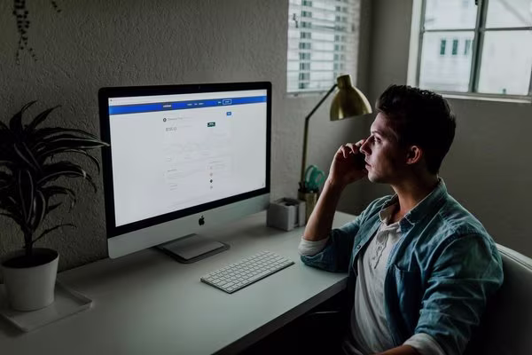 Man looking at bills on computer screen