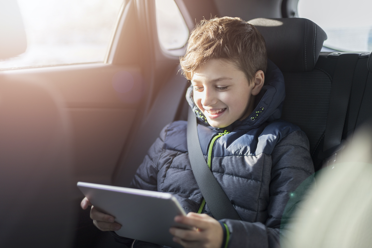Teenager in car with tablet