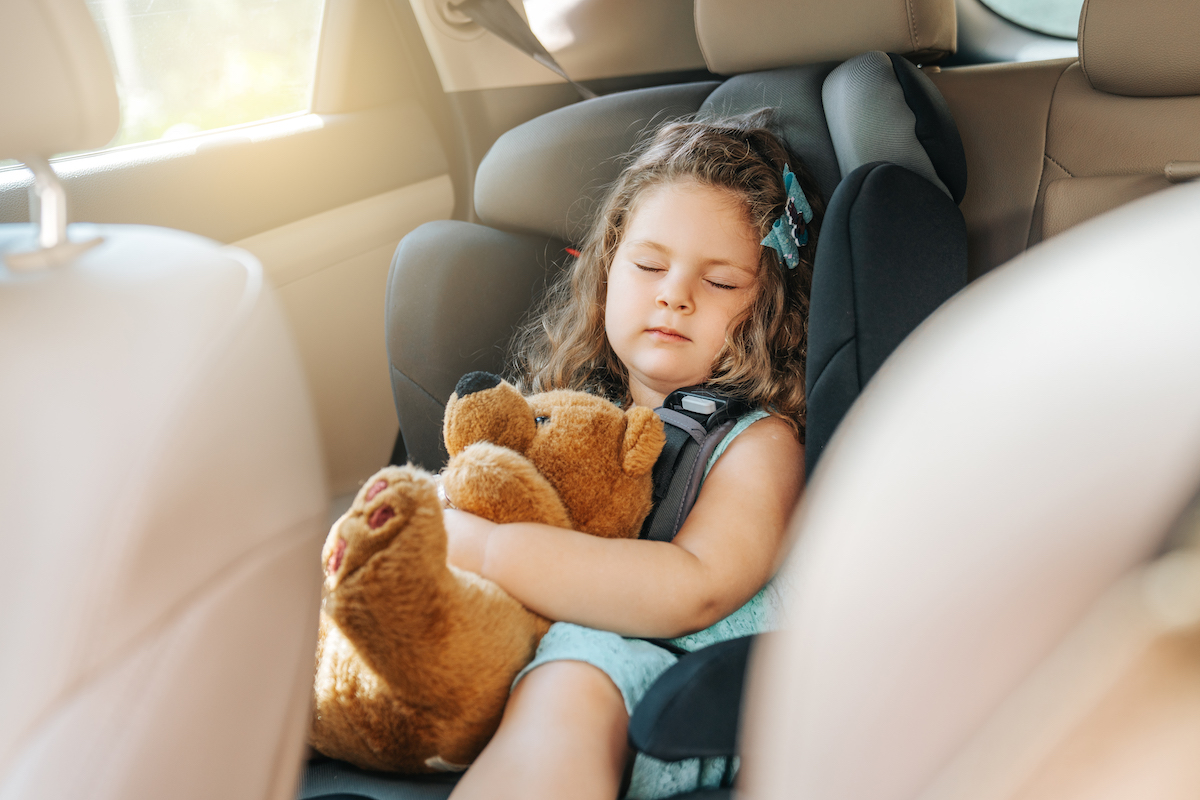 Toddler in car seat with soft toy