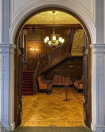 El hall de entrada: boiserie, escalera de madera y piso de roble