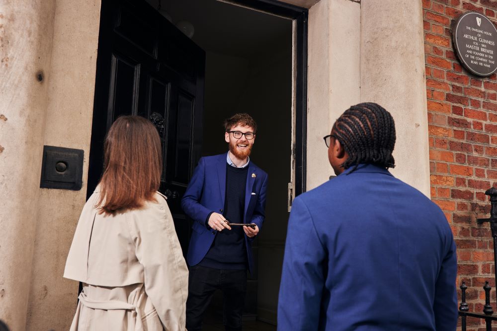 Member of staff greeting visitors in front of Arthur Guinness' former house