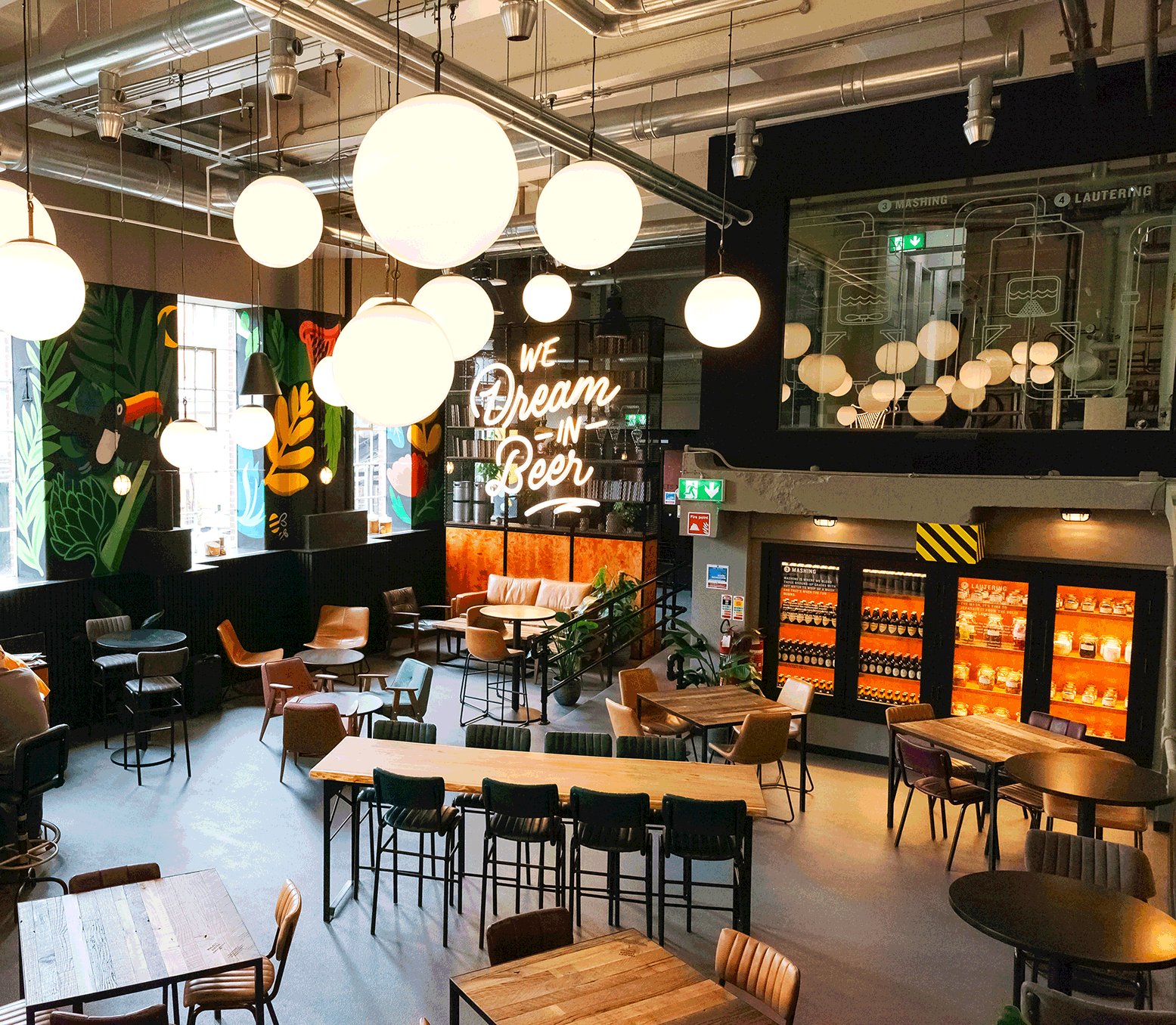 Guinness Open Gate Brewery interior view showing room with tables and chairs and a sign that says 'We Dream In Beer'