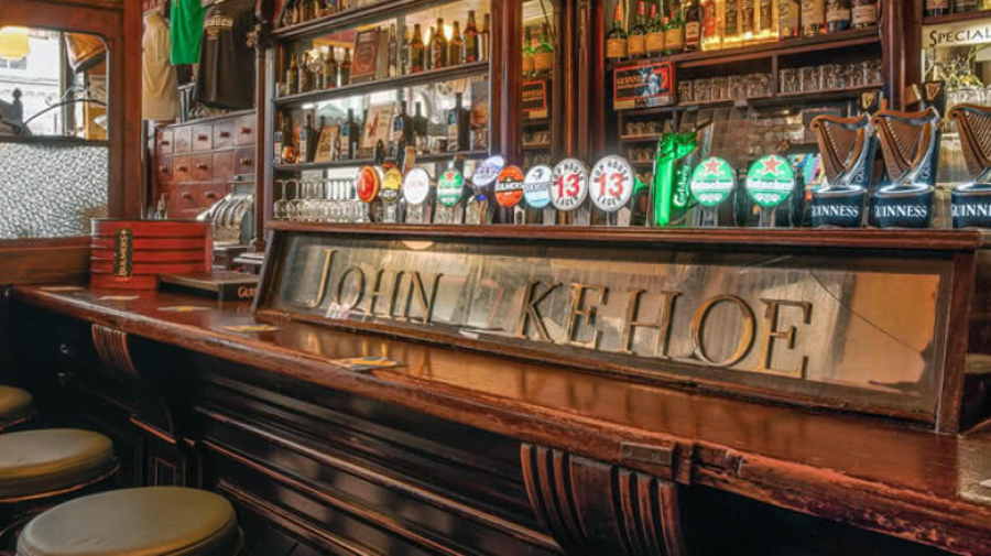 View of a bar featuring various beer taps and distilled beverage bottles on the background