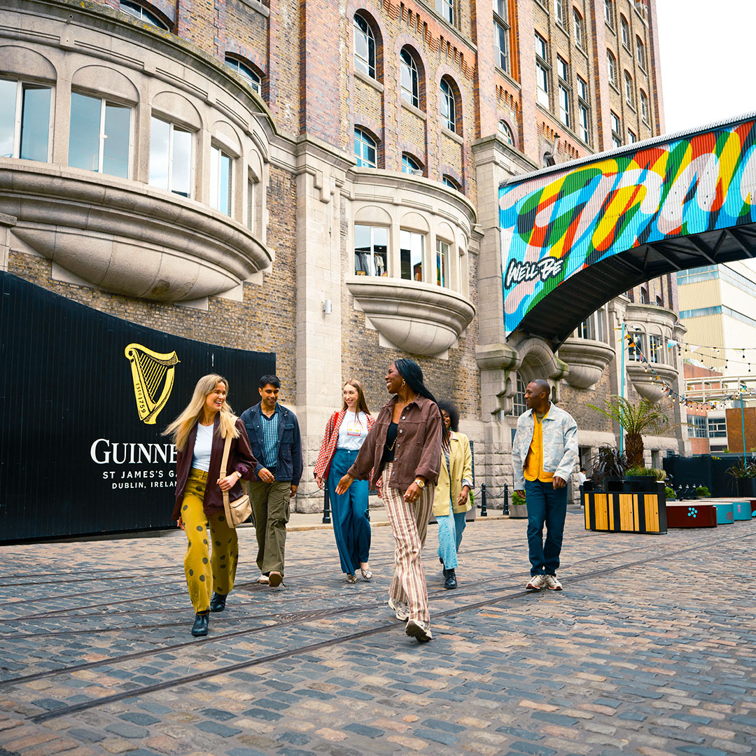 A group of friend entering the Guinness Storehouse Cobble yards with the iconic black gate in the background