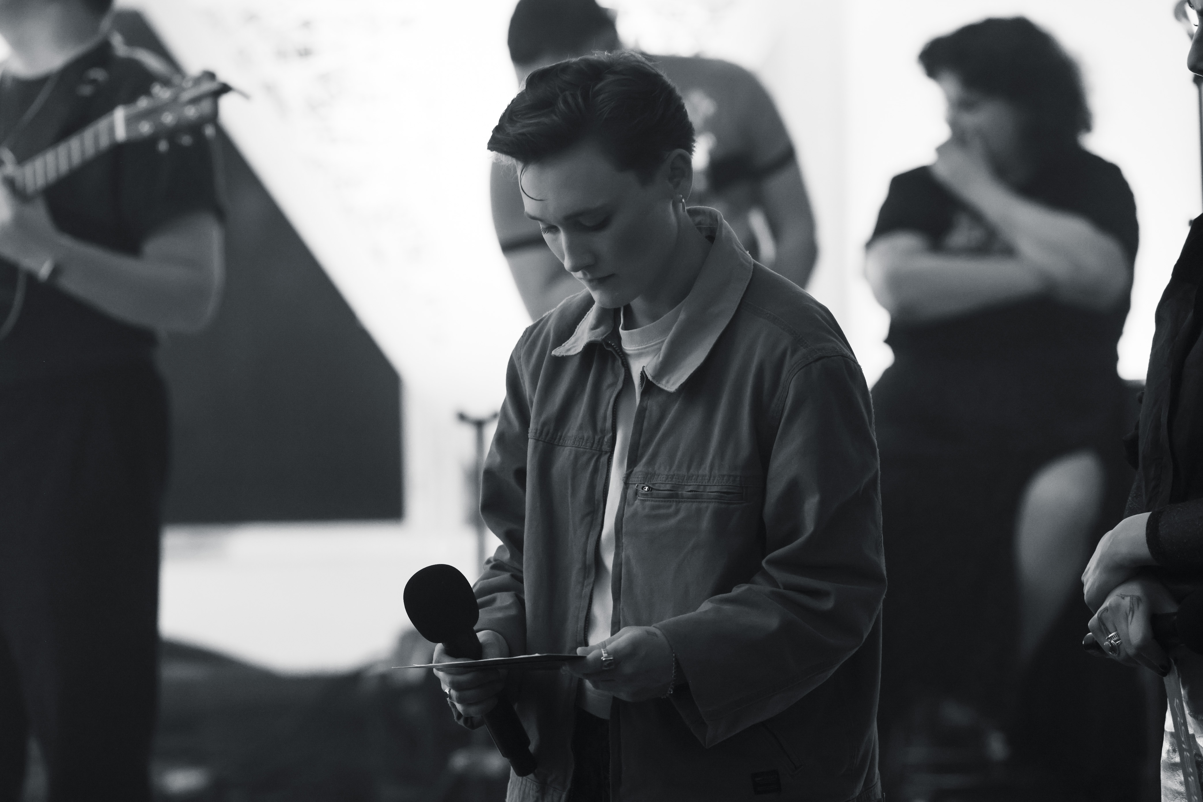 A Black and White photo of the music artist reading from a card