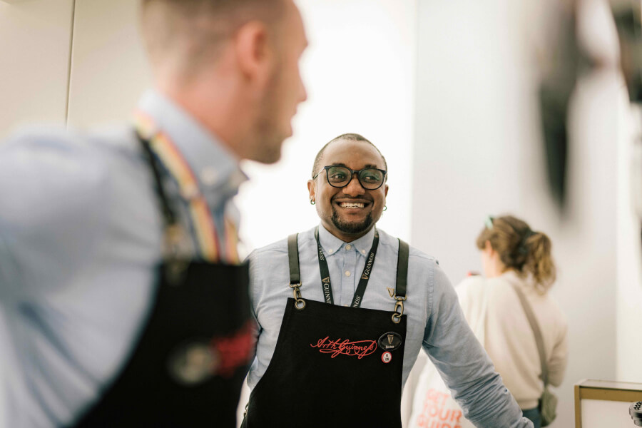 Two Guiness Storehouse employees laughing and talking in the storehouse