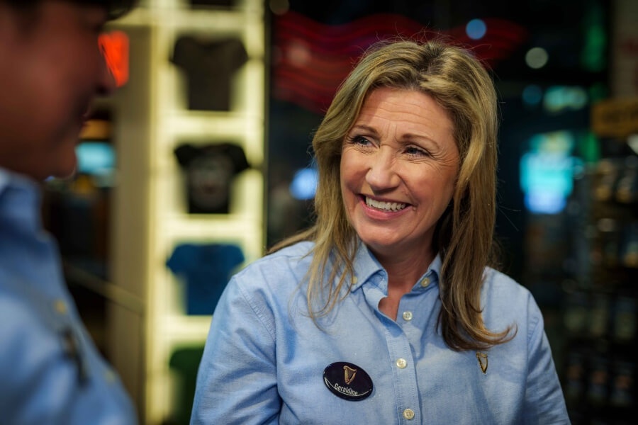 A smiling woman who works at Guinness Storehouse in a retail shop
