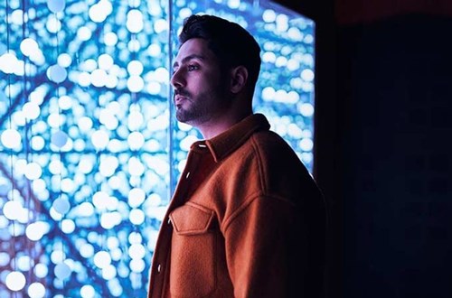 Man staring in front of a wall of blue lights