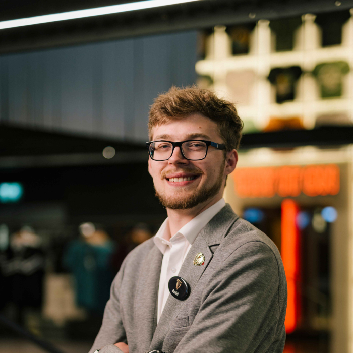 A happy employee working in the Guinness Storehouse on his laptop