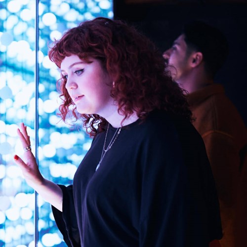 Woman touching a wall with blue lights