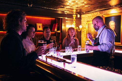 Tour guide explaining to visitors the difference on the taste of the Guinness extra stout