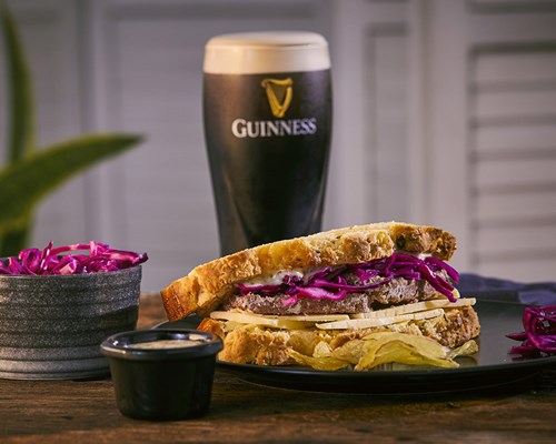 Guinness Garlic and Cumin Njahi Stew with rice, pint of Guinness and bottle of Guinness Foreign Stout on table