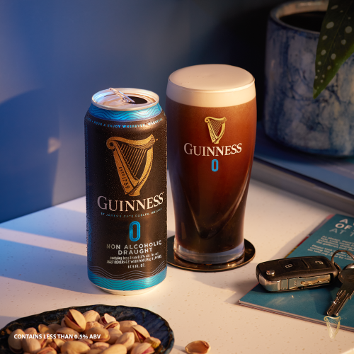 Pint of Guinness 0.0 beside a can of Guinness 0.0 and a side of peanuts