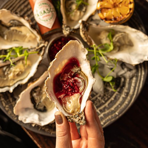 Top view of Carlingford oysters, mignonette, lemon, and tabasco sauce.