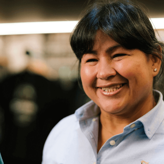 A smiling woman who works at Guinness Storehouse stands in front of the storehouse