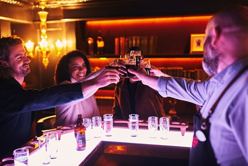 Happy friends and tour guide toasting with a pint of Guinness during their Connoisseur Experience