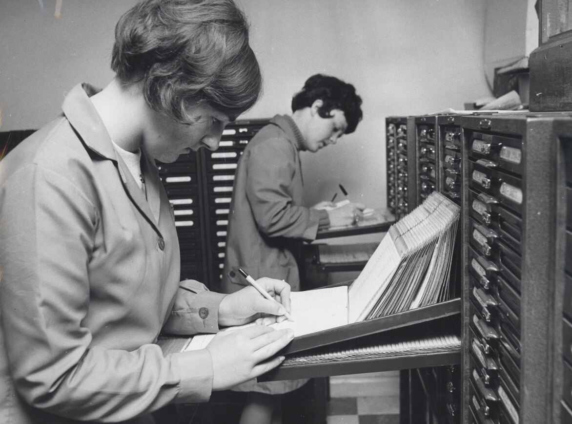 Two female Guinness employees at a filing cabinet, c. 1970.