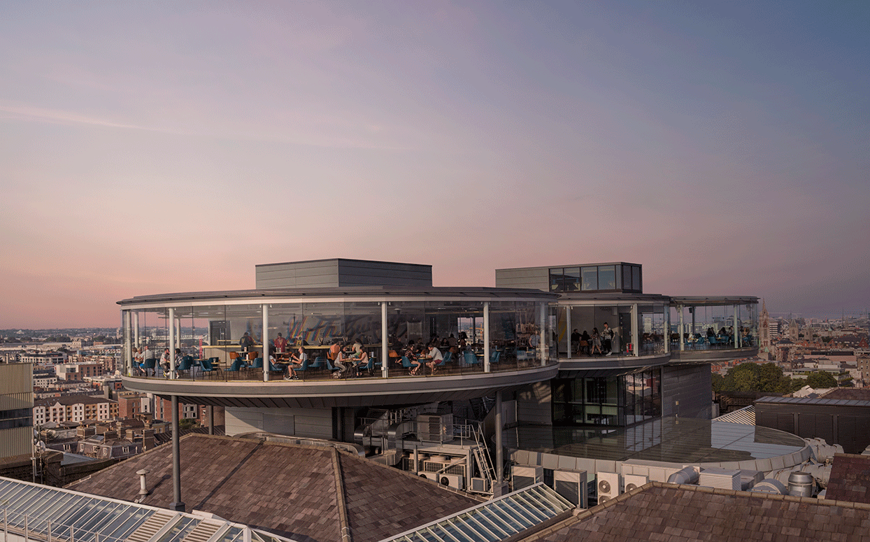 An aerial view of the Gravity bar at sunset, with people sitting in it enjoying a pint of Guinness