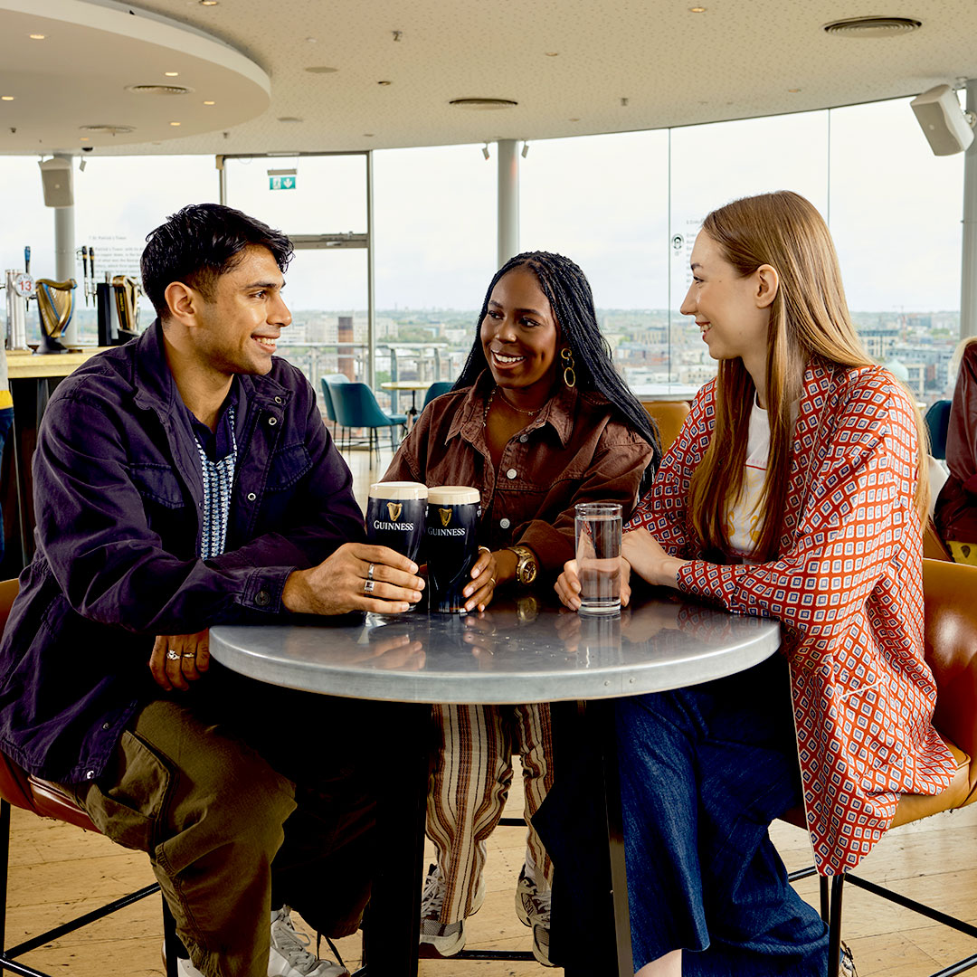 Three friends at the Gravity Bar enjoying their pints on a sunny day