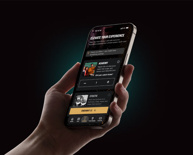 Person holding a smartphone displaying the Guinness Storehouse app while exploring the visitor experience.