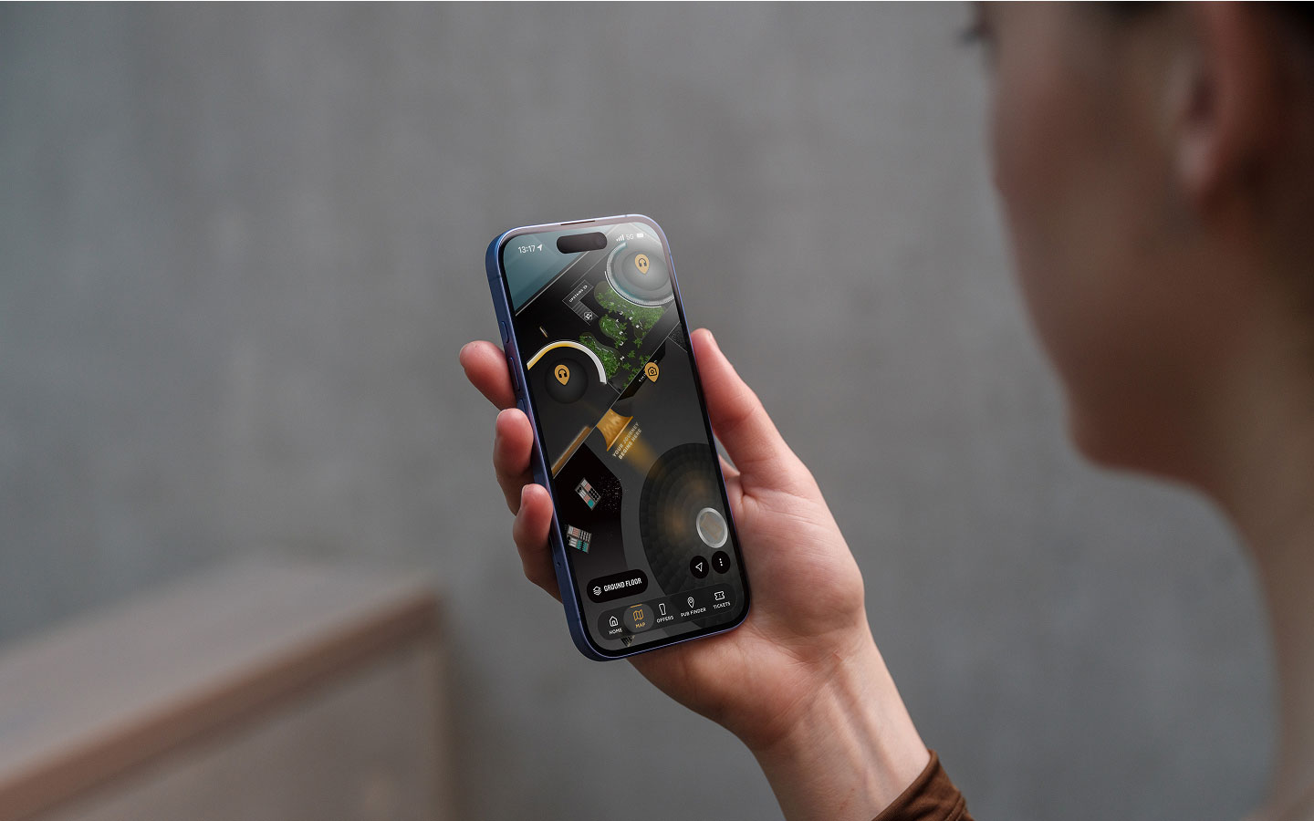 Person holding a smartphone displaying the Guinness Storehouse app while exploring the visitor experience.