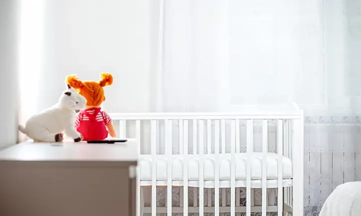 A crib and toys in a room set up for safe sleep