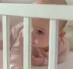 Baby in crib during Ferber Method sleep training