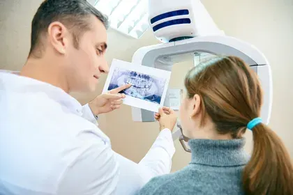 Dentist Showing X-Ray to Patient