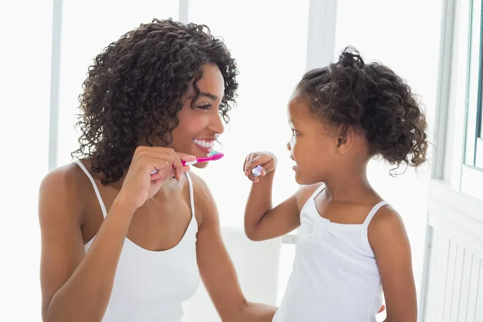 young-girl-and-mom-brushing-teeth