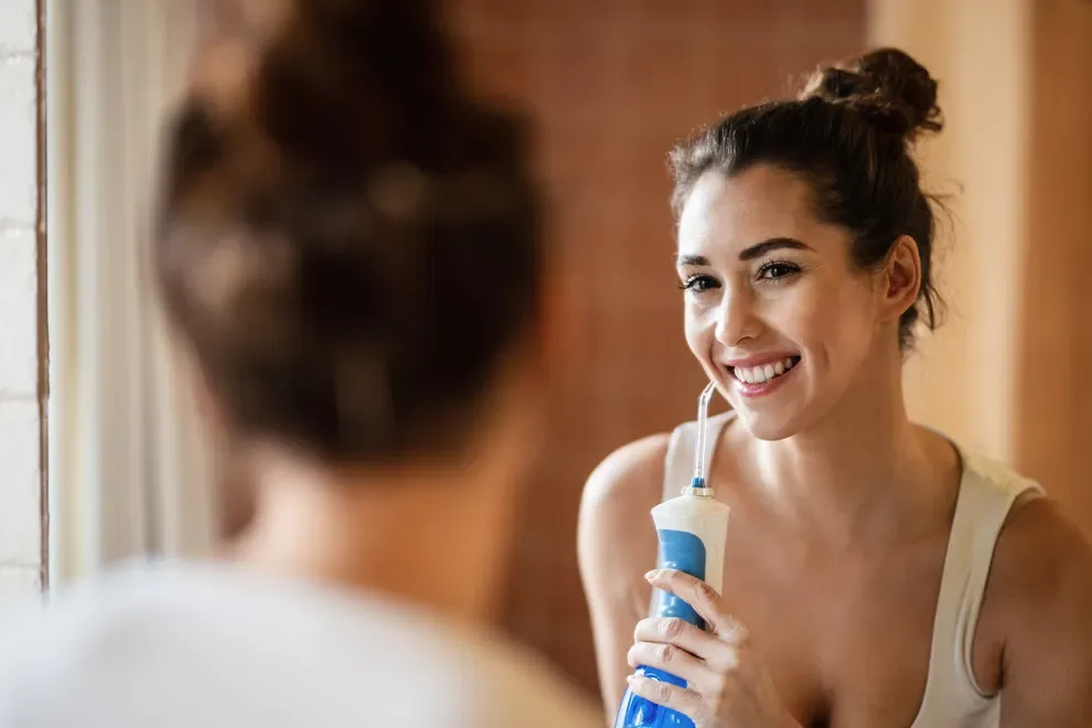 Woman Smiling Using Water Flosser