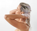 Model applying Custom Purple Hair Mask on her hair in shower.