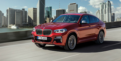 BMW X4 jadące na tle miasta