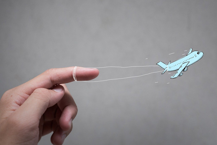 A hand illustration tied to an airplane