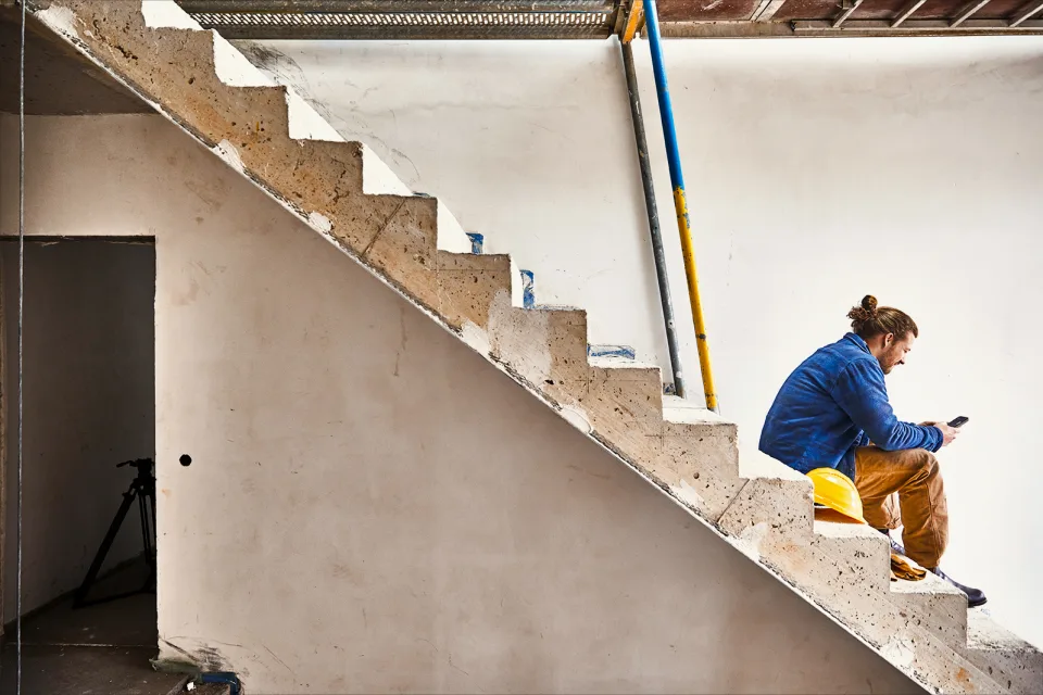 Mann sitzt auf einer Treppe Baustelle
